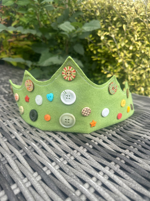 Sage green felt crown decorated with colourful buttons of various shapes and sizes