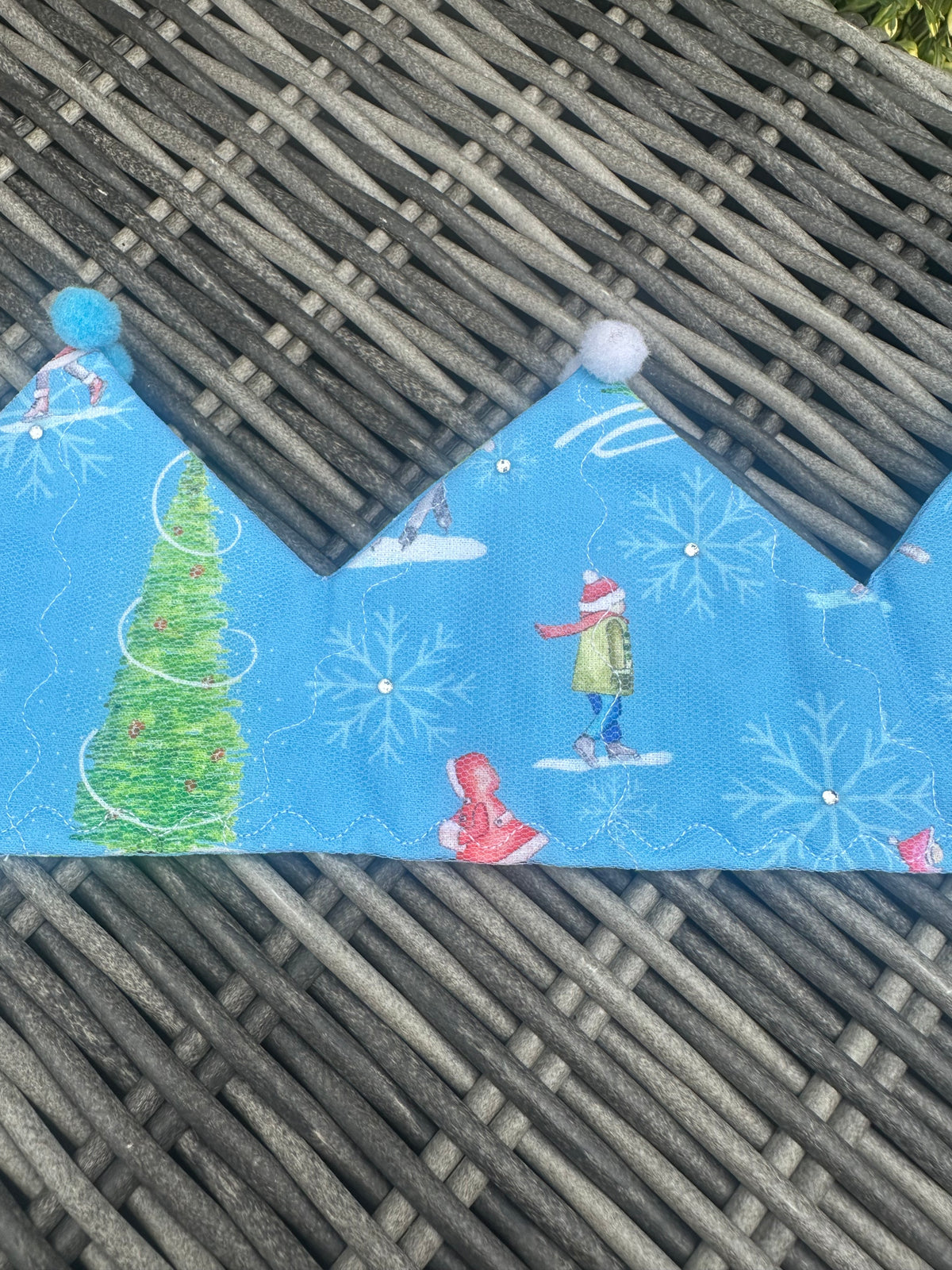Blue fabric crown with winter skaters, Christmas tree, snowflakes and blue and white pom-poms