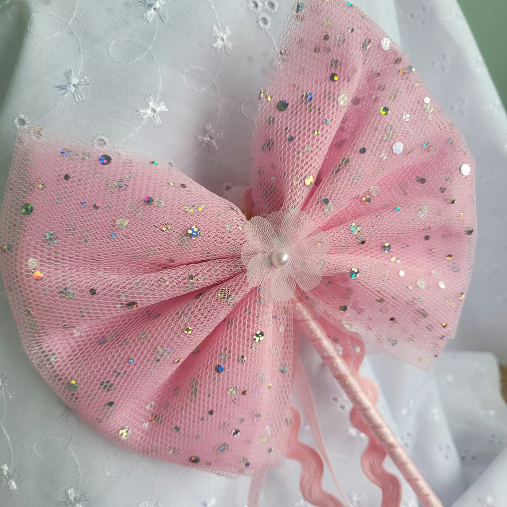 Close view of pink tulle bow wand with sparkling sequins and pearl-like flower centre