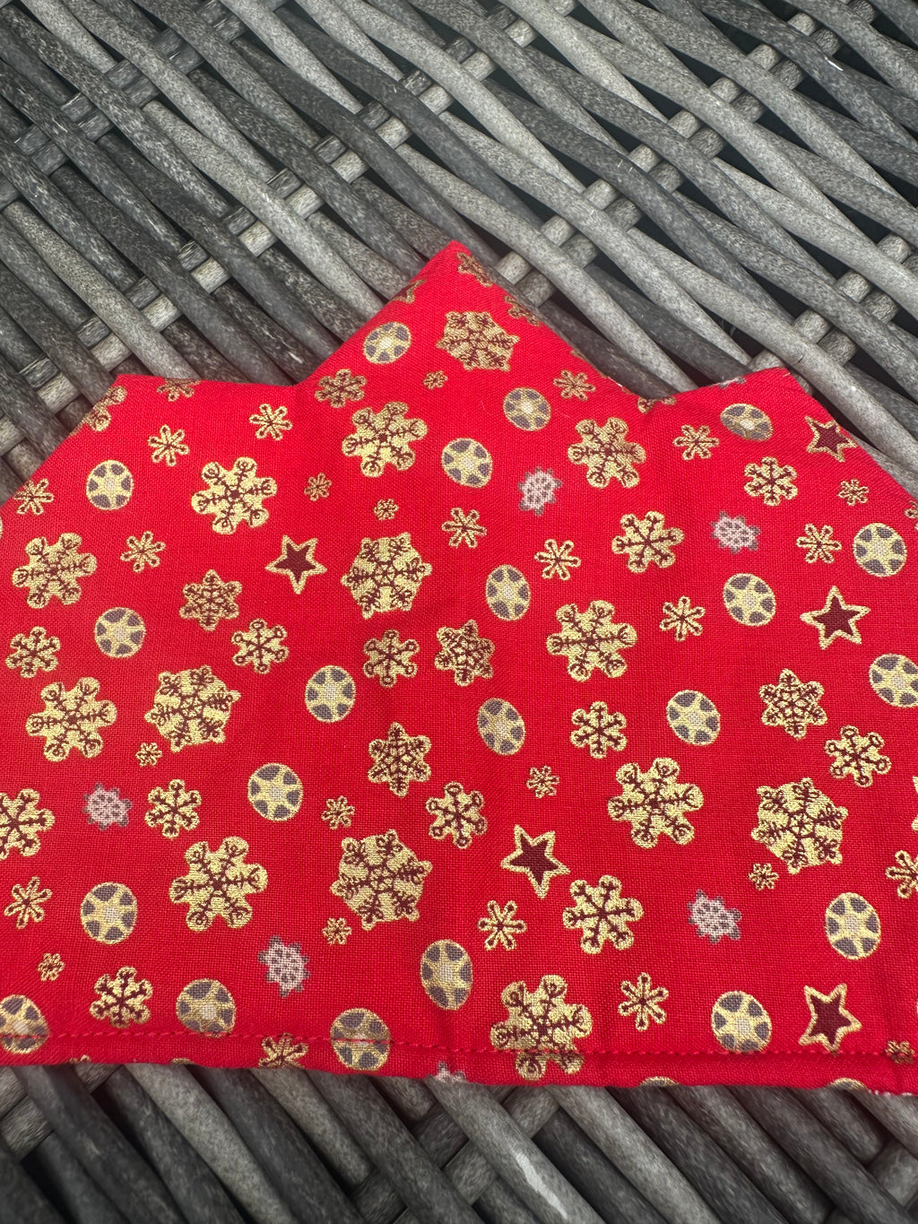 Close-up of the red fabric and gold snowflake print on a Christmas crown