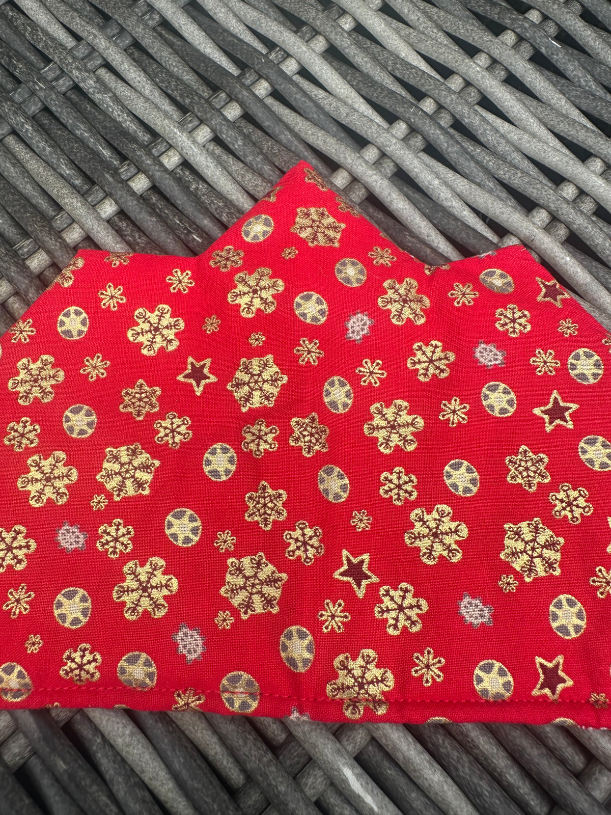 Close-up of the red fabric and gold snowflake print on a Christmas crown