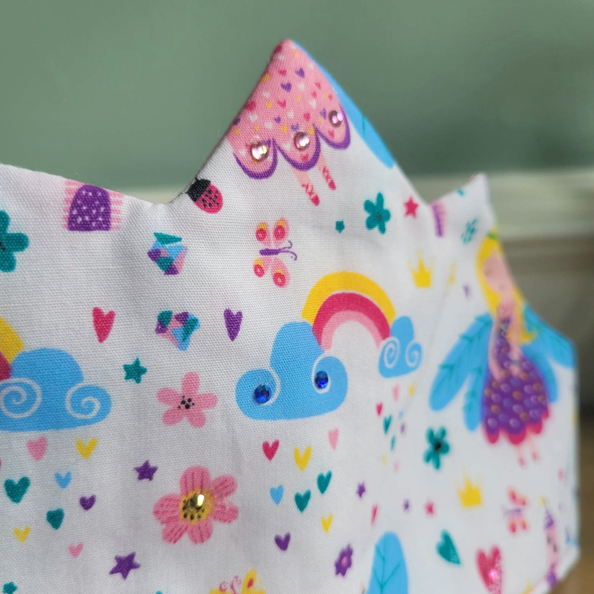 Close-up of fairy crown print with rainbow, flowers and sparkling gem accents