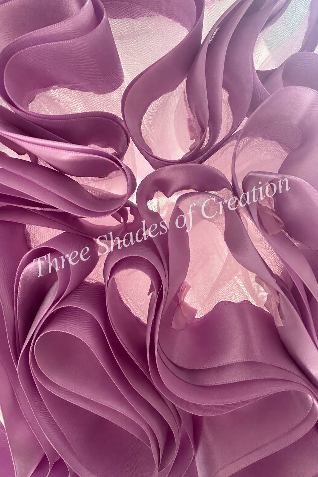 Lilac satin ribbon close-up with translucent Three Shades of Creation watermark