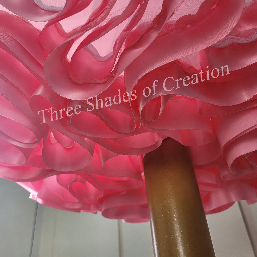 Pink satin ribbon underside with translucent Three Shades of Creation watermark