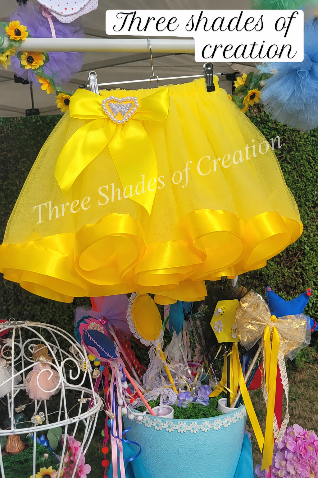 Yellow ribbon tutu on display with translucent Three Shades of Creation watermark