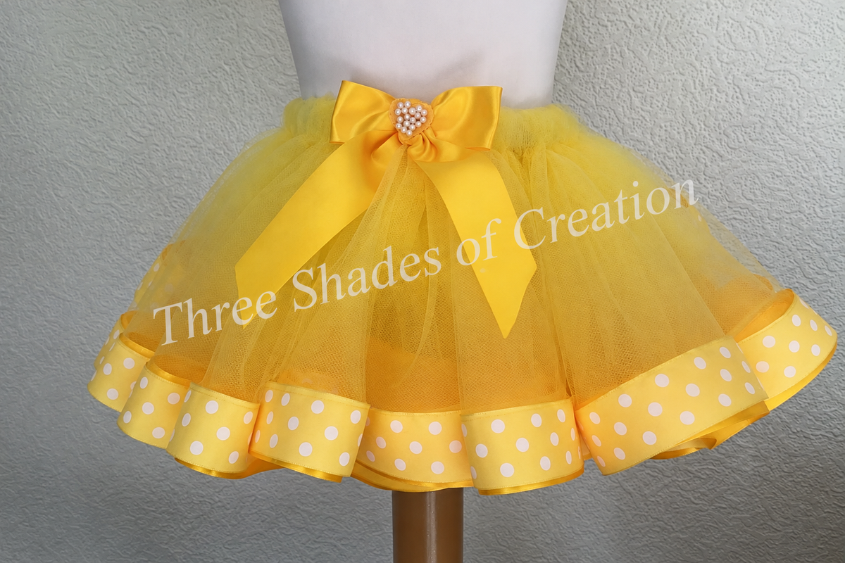 Yellow polka-dot tutu close view with translucent Three Shades of Creation watermark