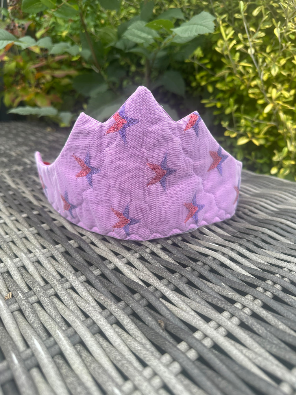 Close-up of a lilac star-print fairy crown with red and purple star details