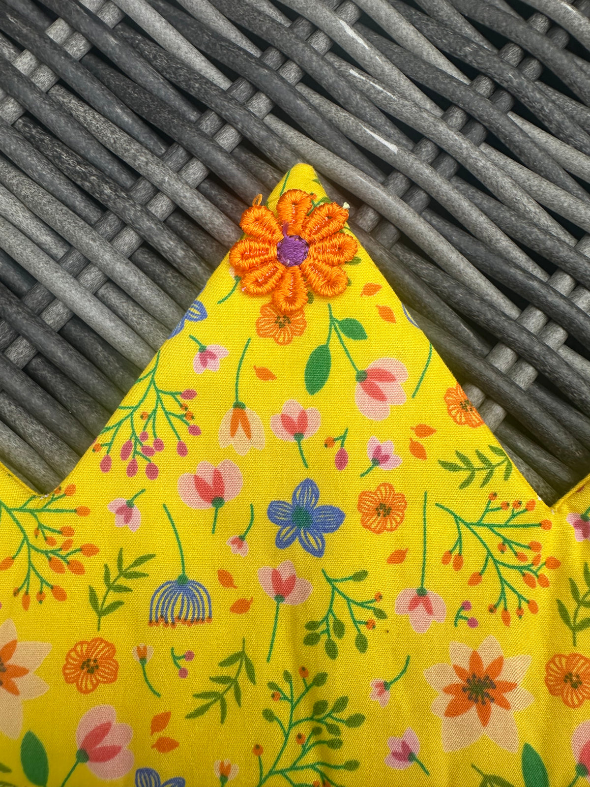 Close-up of the bright yellow floral crown fabric and colourful flower embellishment