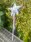 Peter Rabbit fabric star wand with colourful pom-poms and trailing ribbons outdoors