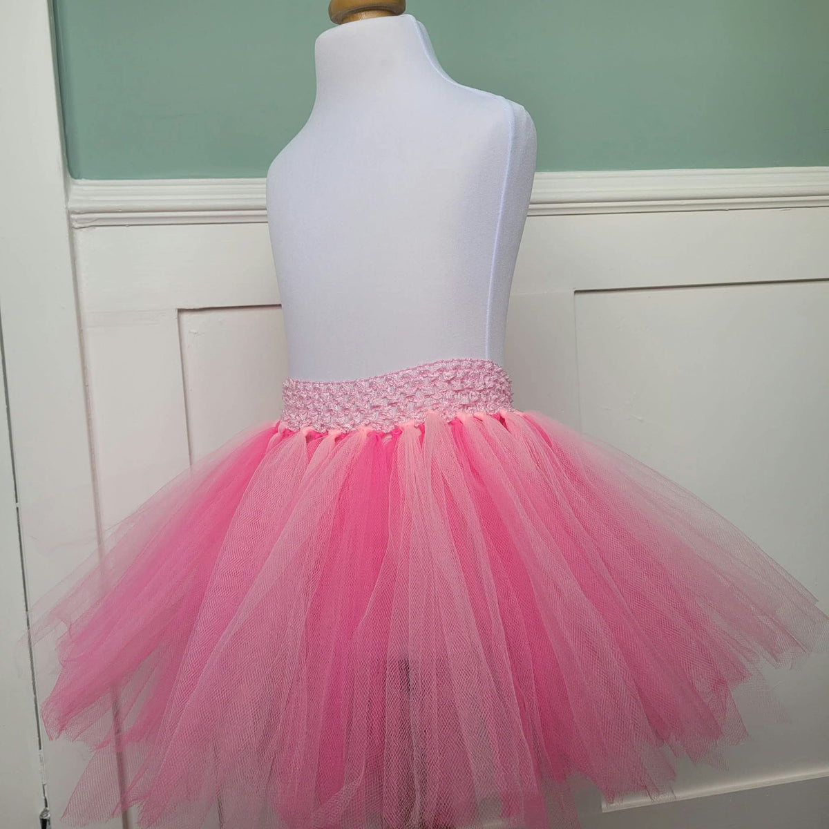 Full view of pink layered tulle tutu skirt on dress form