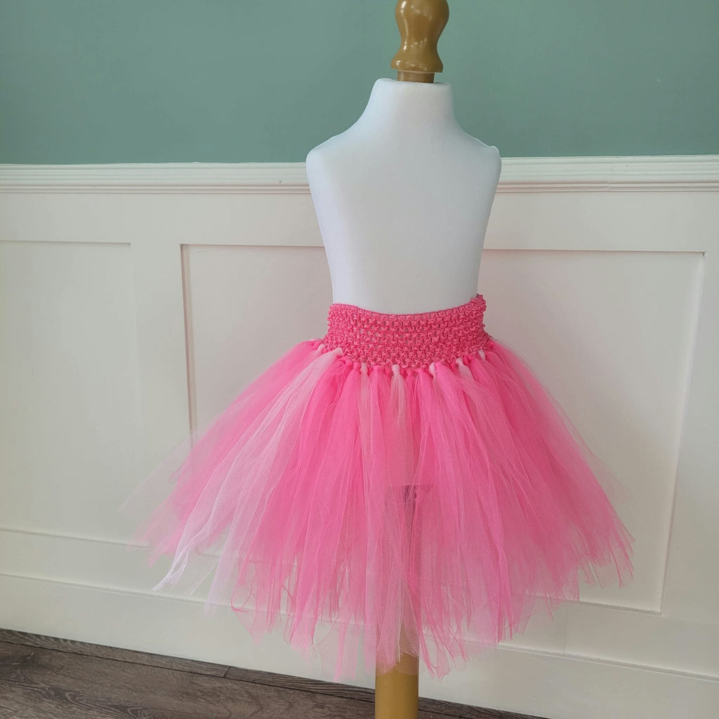 Full view of bright and pale pink tulle tutu skirt with pink crochet waistband on dress form