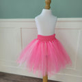 Full view of bright and pale pink tulle tutu skirt with pink crochet waistband on dress form