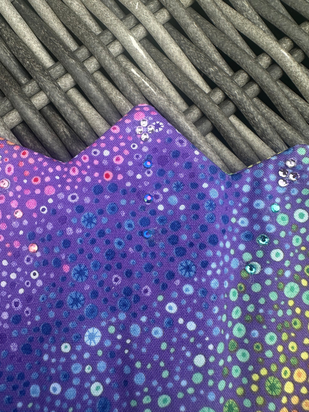 Close-up of the colourful shimmering dot pattern on a purple crown