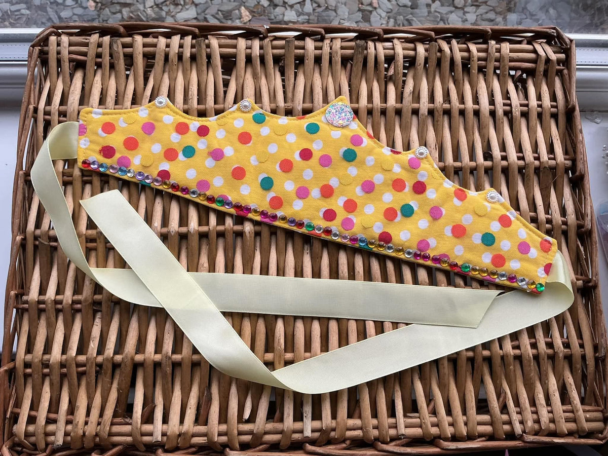 Handmade yellow polka dot fabric crown with rainbow rhinestone trim and cream satin ribbon ties