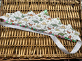 Handmade white dinosaur print fabric crown with multicolour gem bead base trim and large green gem centrepiece