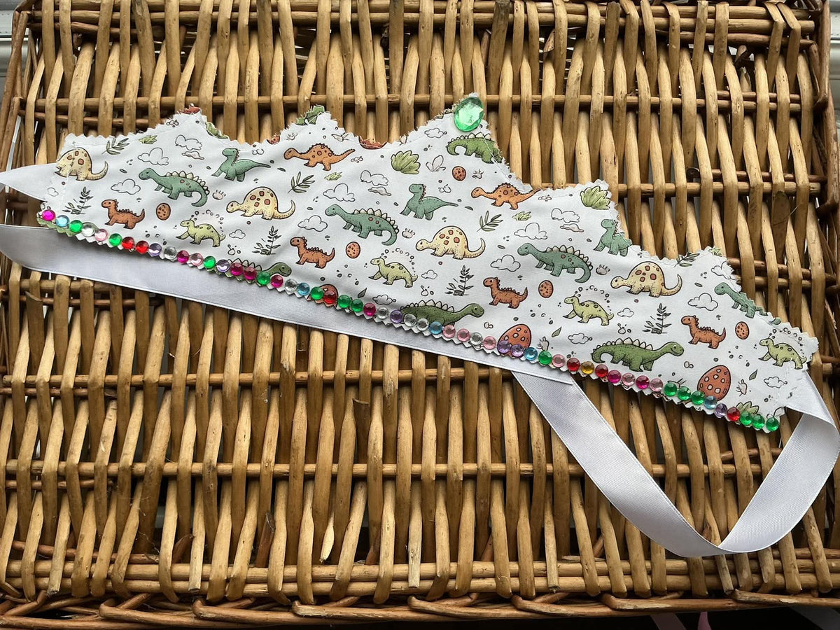 Handmade white dinosaur print fabric crown with multicolour gem bead base trim and large green gem centrepiece